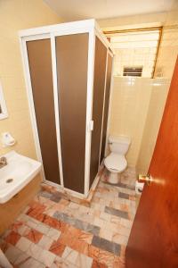 a bathroom with a toilet and a sink at Hotel Tres Colonias - S&oacute;lo Adultos in Mexico City