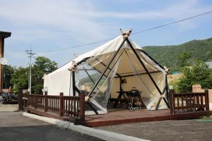 a large white tent with a wooden deck at Daegwanryeong Rodem Tree Pension in Pyeongchang