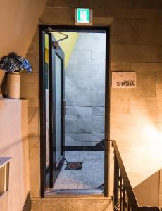 首爾的住宿－Guest House ShaSha，通往楼梯的敞开门,上面有标志