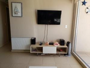 sala de estar con TV en la pared en Departamento Laguna Bahia, en Algarrobo