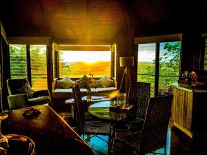 uma sala de estar com uma mesa e cadeiras e um sofá em Mt Quincan Crater Retreat em Yungaburra