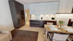 eine Küche und ein Wohnzimmer mit einem Tisch und einem Sofa in der Unterkunft White Pearl Apartment 3.08 in Timmendorfer Strand