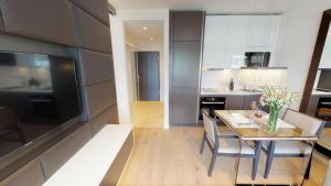 a kitchen and dining room with a wooden table and a dining room at White Pearl Apartment 3.10 in Timmendorfer Strand