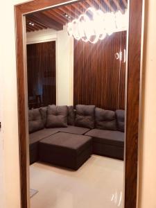 a living room with a couch and a large mirror at Luzville Residences - C5 in Naic