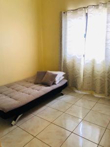 a bed sitting in a room with a window at Luzville Residences - C5 in Naic
