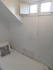 1 dormitorio blanco con 1 cama y 2 ventanas en Tralkan B&B, en Santiago