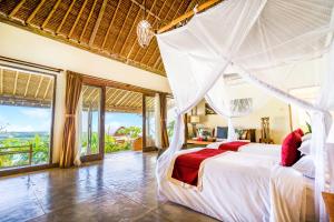 a bedroom with a bed with a mosquito net at Sunhouse, Mandala Village in Uluwatu