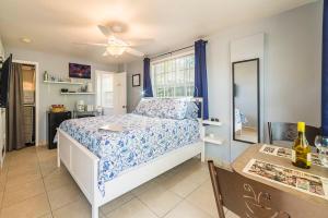 a bedroom with a bed and a table and a window at The Blue Door Inn in Fort Lauderdale