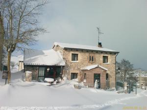 ein Steinhaus im Schnee mit Schnee in der Unterkunft Casa Rural Villamoronta in La Rad