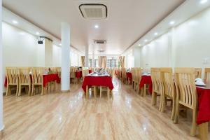 a restaurant with tables and chairs with red table cloth at Quang Minh Hotel in Cat Ba