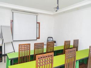 a classroom with green tables and chairs and a whiteboard at RedDoorz Plus @ Cibogo Puncak 3 in Bogor