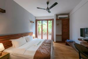 a bedroom with a bed and a ceiling fan at Aveyla Manta Village in Dharavandhoo