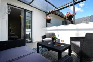 eine Terrasse mit einem Tisch und Stühlen auf dem Balkon in der Unterkunft ONE Luxury Suites Eger in Eger