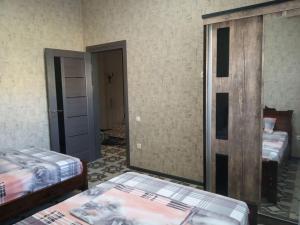 an empty room with two beds and a mirror at Apartment Downtown in Tashkent