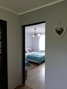 Leśny Apartament في شتشتنو: غرفة نوم بسرير ومرآة