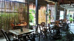 - un restaurant avec des tables et des chaises en bois dans une chambre dans l'établissement Popular Lanta Resort, à Ko Lanta