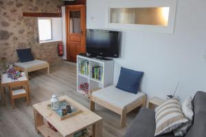 sala de estar con sofá y TV en Casa Rural Marem, en El Rasillo