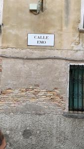 un letrero de la calle en el lateral de un edificio en Corte Emo, en Venecia