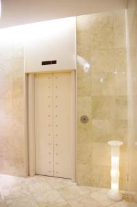 a bathroom with a white door and a shower at Hotel South Garden Hamamatsu in Hamamatsu