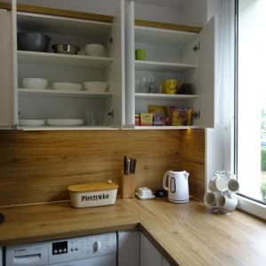 トルンにあるMieszkanie 4-pokojowe w Toruniu przy UMKのキッチン(白いキャビネット、木製カウンタートップ付)