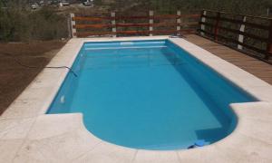 ein großer blauer Pool auf einer Terrasse in der Unterkunft Casa en Balcón de Mallín, Mirador del Lago in Bialet Massé
