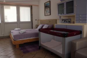 1 dormitorio pequeño con 1 cama y 1 sofá en IL LILLA, en Ankaran