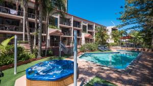 a swimming pool in front of a apartment building at Trickett Gardens Holiday Inn in Gold Coast