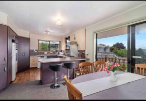 a kitchen with a table and a kitchen with a view at Mountain Top kiwi star holiday home in Rotorua