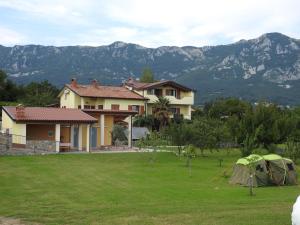 une maison avec une tente et des montagnes en arrière-plan dans l'établissement Turistična kmetija Pri Rebkovih, à Ajdovščina