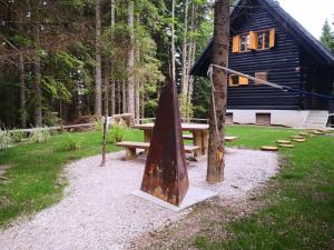 a picnic table and bench in front of a cabin at Cosy Lodge Pokljuka in Goreljek