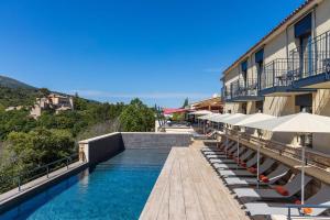 um hotel com uma piscina com cadeiras e guarda-sóis em Hôtel Sainte Victoire em Vauvenargues