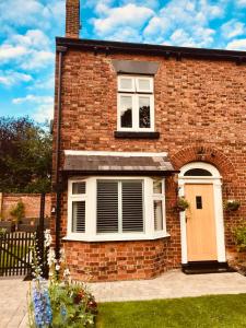 a brick house with a window and a door at Eden Cottage in Frodsham