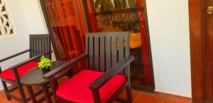 two chairs with red cushions and a potted plant at La Niche D'angkor Boutique Hotel in Siem Reap