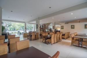 ein Esszimmer mit Tischen und Stühlen in einem Restaurant in der Unterkunft Hotel Yehezkiel Surapati Mitra RedDoorz in Bandung