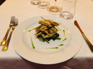 a white plate with food on a table at Albergo Cappello in Ravenna