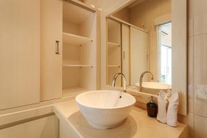 a white bathroom with a sink and a mirror at Villa Julie & Villa Sydney, Seminyak - 2 Bedroom Modern Pool Villas! in Seminyak