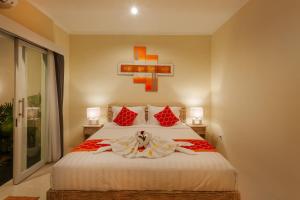 a bedroom with a bed with a cross on the wall at Villa Julie & Villa Sydney, Seminyak - 2 Bedroom Modern Pool Villas! in Seminyak +59 photos