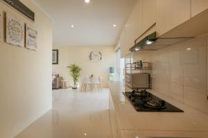 eine große weiße Küche mit Herd und Stühlen in der Unterkunft Villa Julie & Villa Sydney, Seminyak - 2 Bedroom Modern Pool Villas! in Seminyak