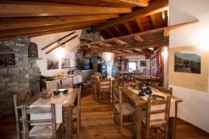 a restaurant with wooden tables and chairs and a stone wall at L'Or d'Echallogne - Chambre d'Hôtes in Arnad +41 photos