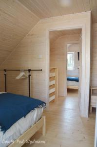 a bedroom with a bed in a wooden room at Domki Pod Wydmami in Międzywodzie