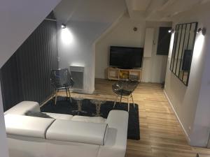 sala de estar con sofá blanco y TV en Loft duplex neuf 65m2 (clim) au coeur de La Baule les Pins, en La Baule