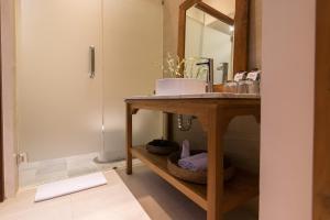 a bathroom with a sink and a vanity with a mirror at Ulun Ubud Resort - CHSE Certified in Ubud