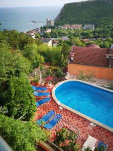 a swimming pool with lounge chairs and the ocean at Complex Karia II in Kavarna