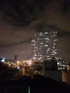 a tall building lit up at night at xh apartment in Danang