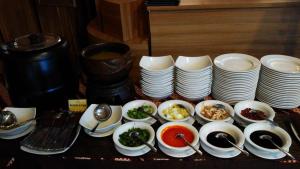 una mesa con platos y cuencos de comida y cucharas en Hotel Namira Syariah Pekalongan, en Pekalongan
