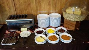 a table with plates and bowls of food and a toaster at Hotel Namira Syariah Pekalongan in Pekalongan