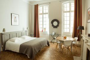 Maison Dormoy في مارسيليا: غرفة نوم بسرير وطاولة وكراسي
