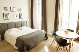 a bedroom with a bed, chair, table and a lamp at Maison Dormoy in Marseille