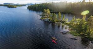 una vista aérea de un lago con 2 personas en kayaks en Wilderness Hotel Nellim & Igloos en Nellimö