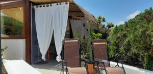 une paire de chaises assises sur une terrasse couverte avec chapiteau dans l'établissement dammuso veranda vista mare, à Pantelleria